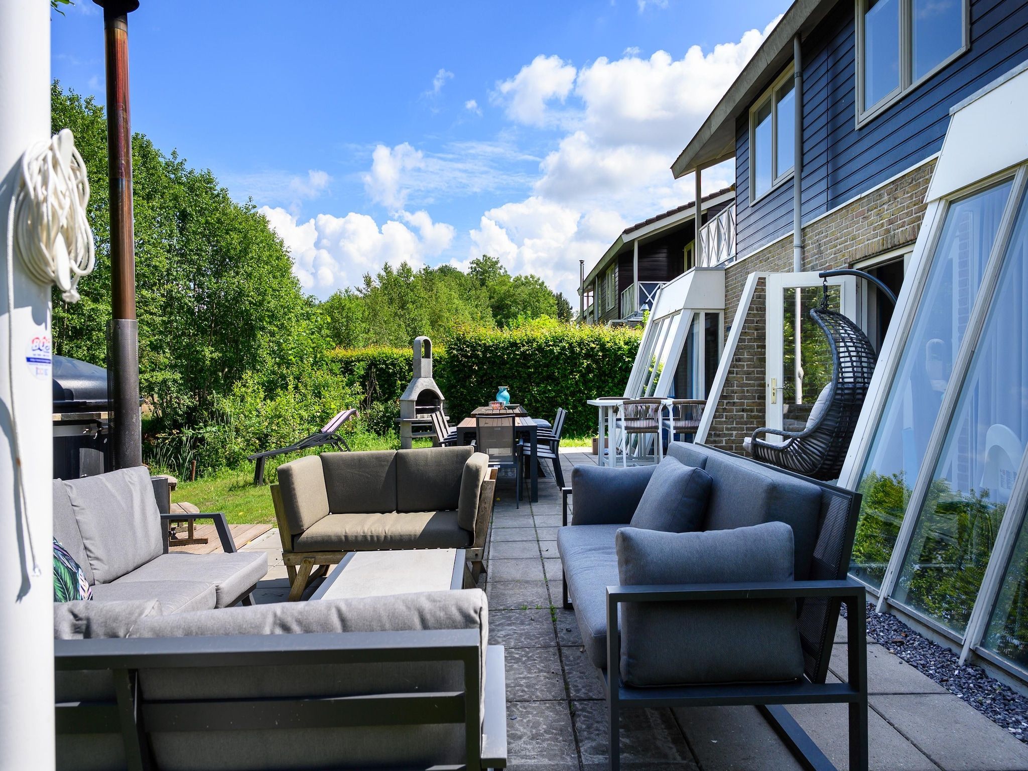Het terras van 18 pers Ellersinghuis wellness met houtgestookte hottub in Vlagtwedde