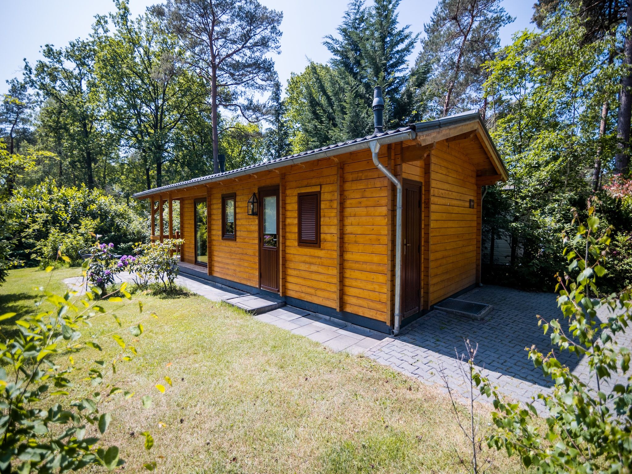 De tuin van 2-persoons wellness lodge in Markelo