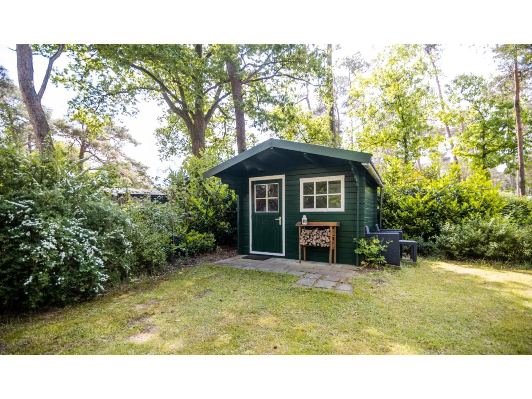 De tuin van 4-persoons stenen bosvilla in Markelo