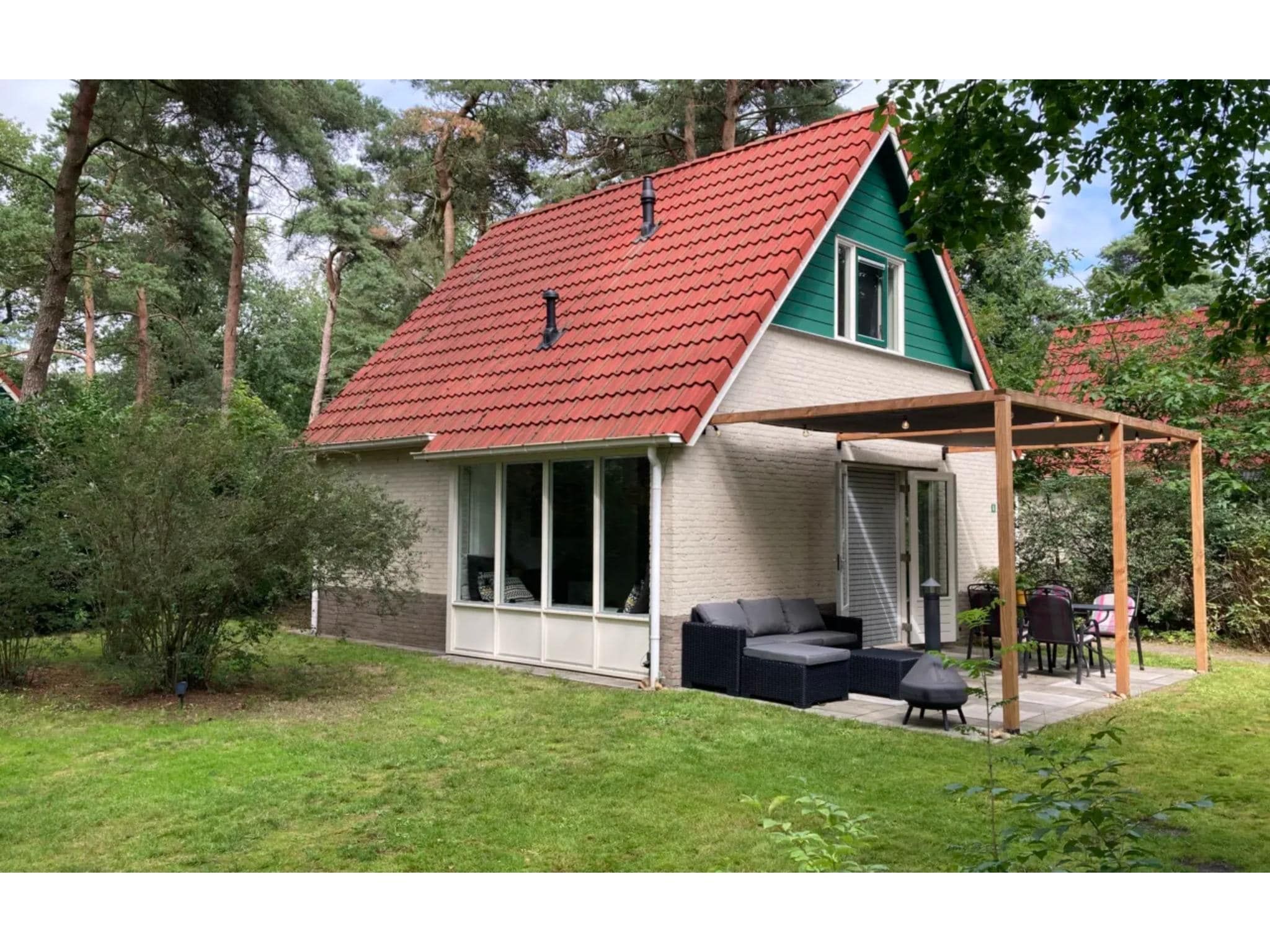 De buitenkant van 4-persoons stenen bosvilla in Markelo