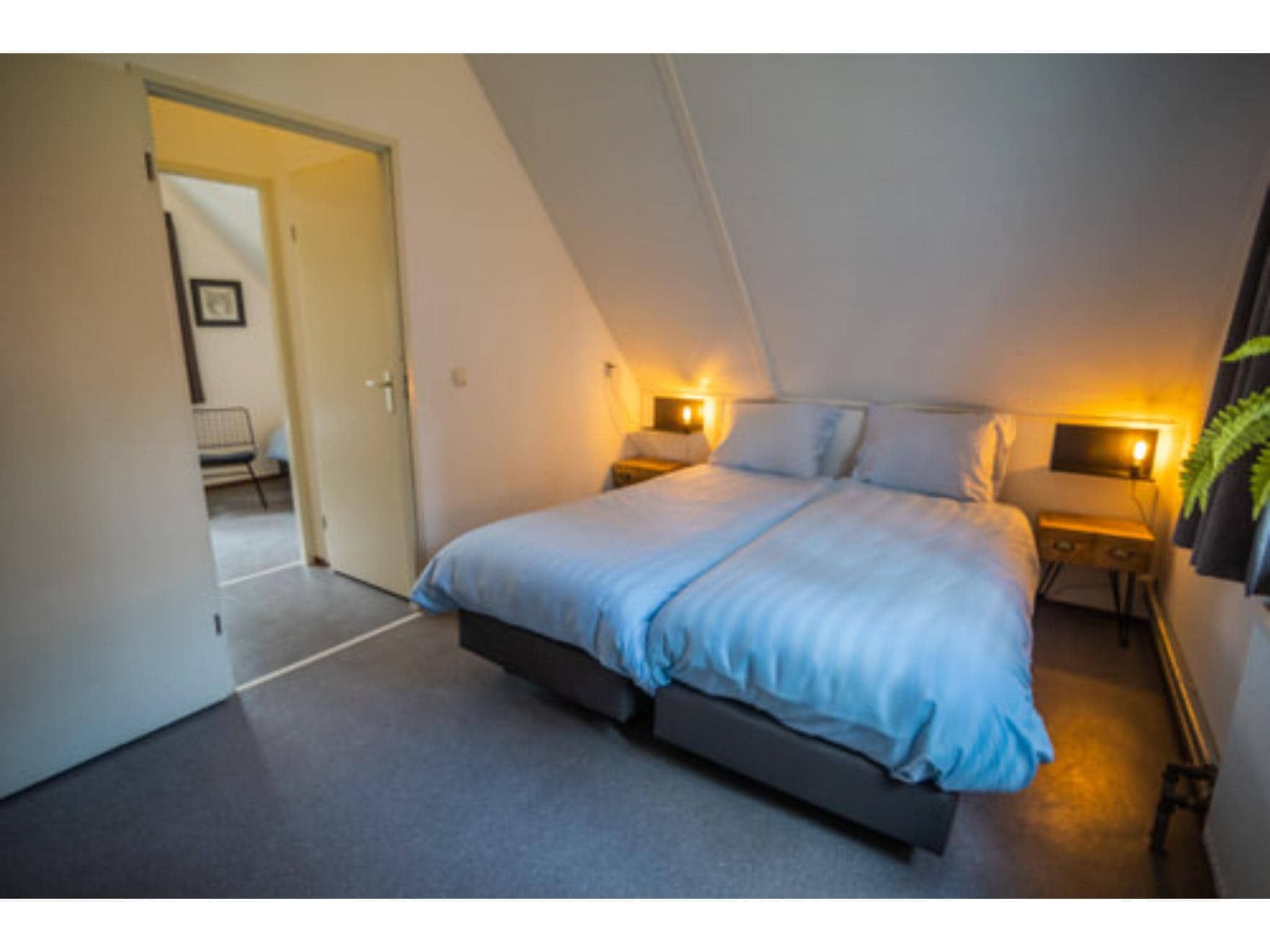 Een slaapkamer van 4-persoons stenen bosvilla in Markelo