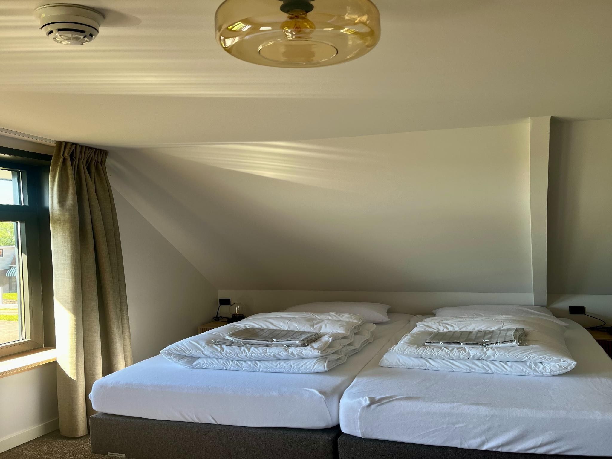 Een slaapkamer van Groepsaccommodatie met 10 luxe tweepersoons kamers in Scherpenzeel (FR)