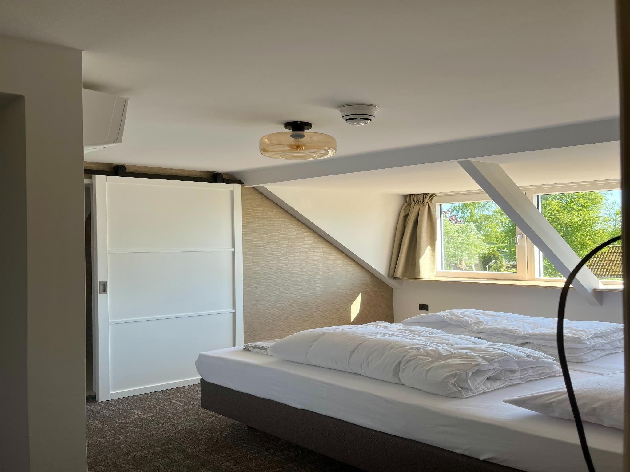 Een slaapkamer van Groepsaccommodatie + 4 large greenhouses (36 personen) in Scherpenzeel (FR)