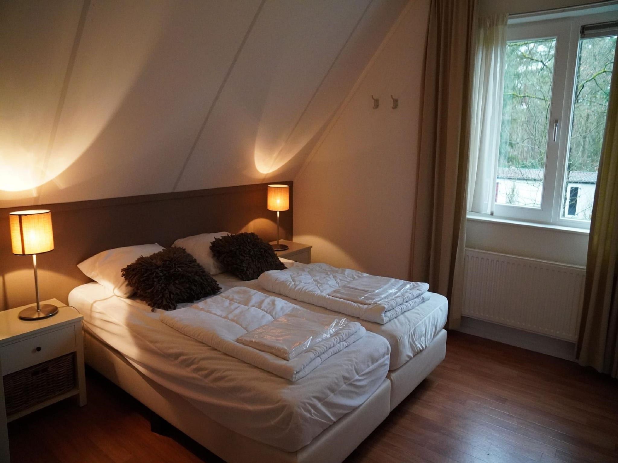 Een slaapkamer van Vakantiepark De Rimboe & De Woeste Hoogte 2 in Hoenderloo