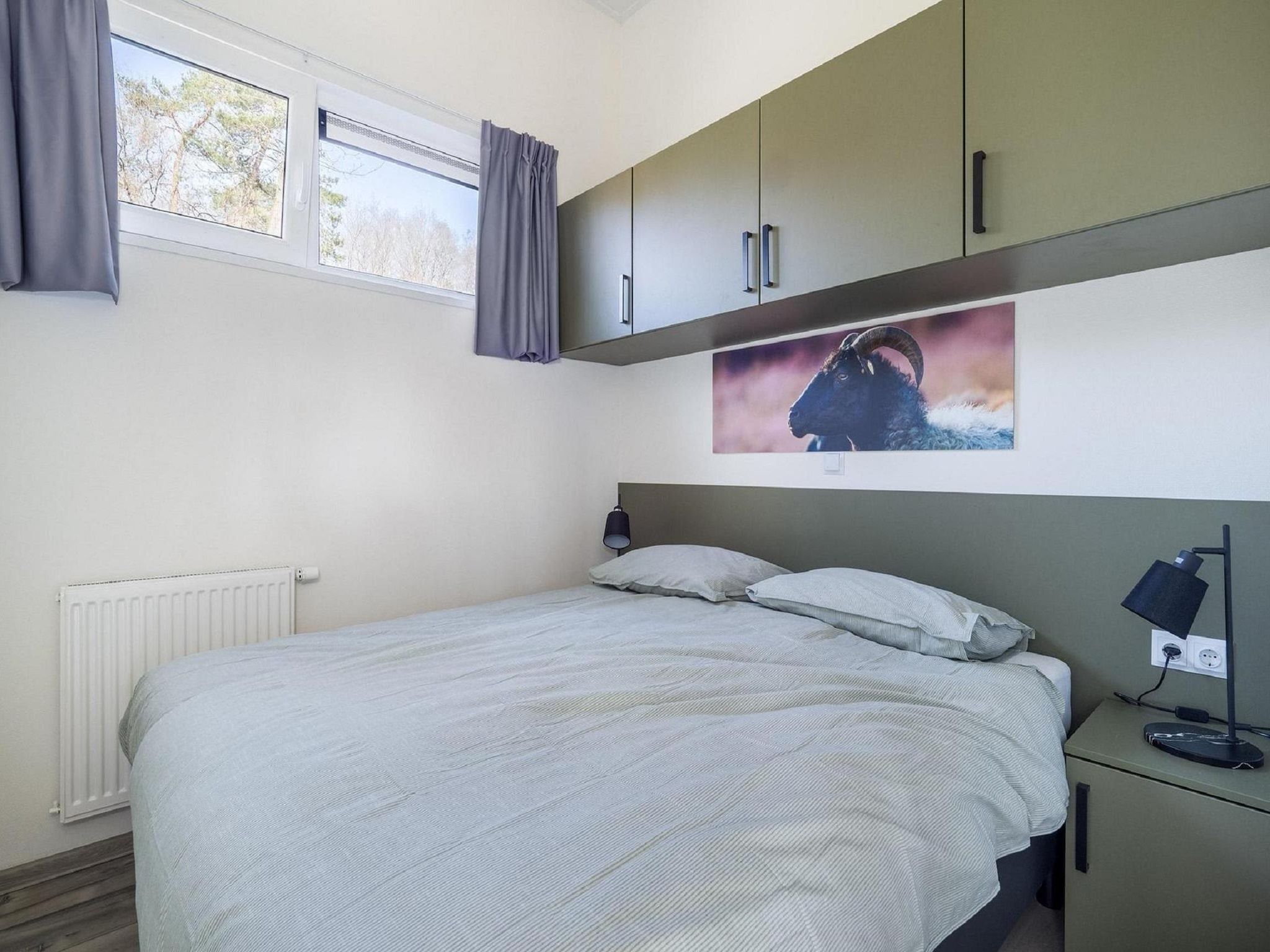 Een slaapkamer van Vakantiepark De Rimboe & De Woeste Hoogte 24 in Hoenderloo