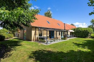 Vrijstaande groepsaccommodatie voor 12 personen met tuinkamer en houtkachel in Andijk